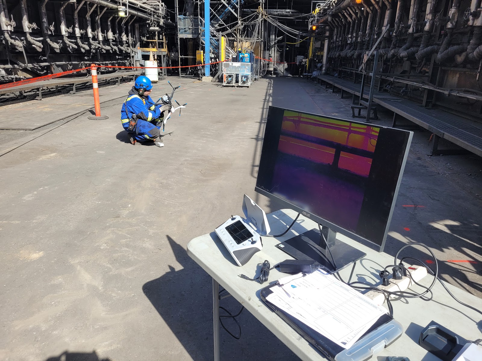 Technician inside a confined space with a caged drone