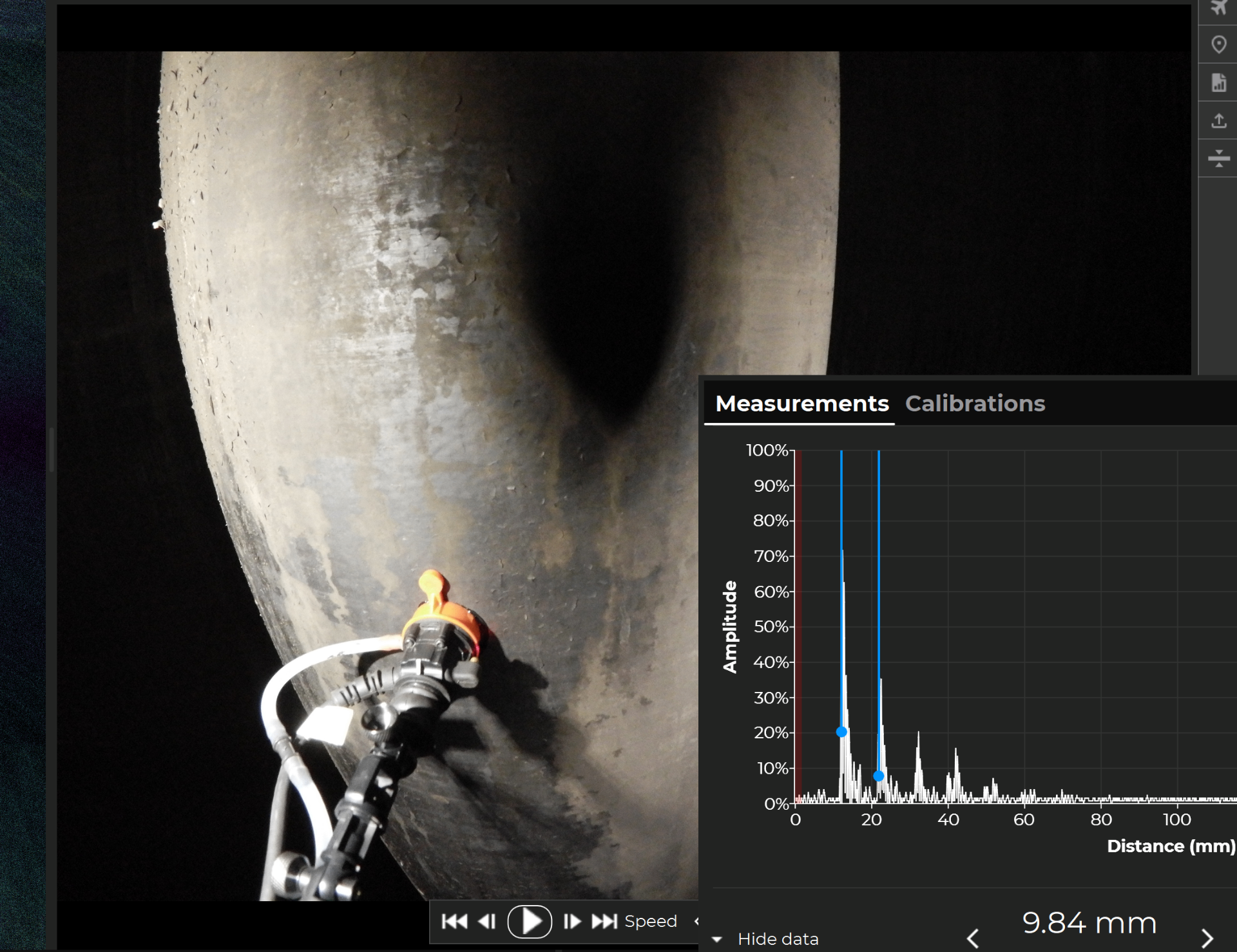 Ultrasonic thickness probe on a tank wall with measurement amplitude readout