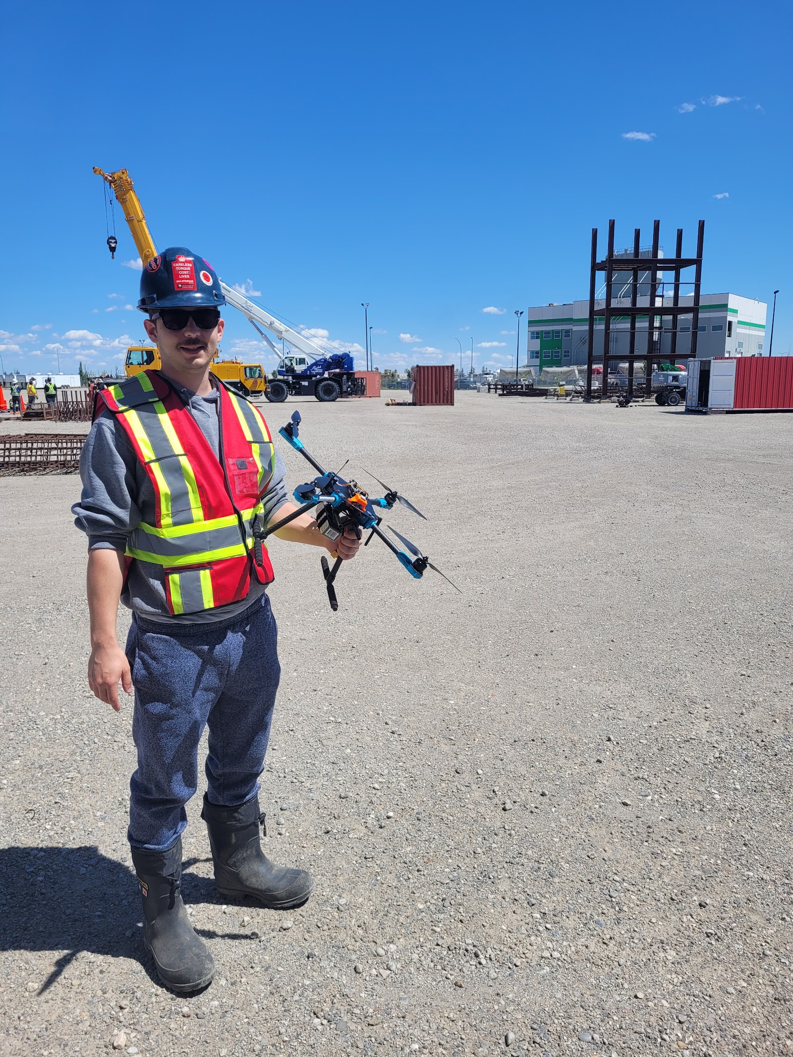PRX pilot holding a multirotor with a crane and structure in the background