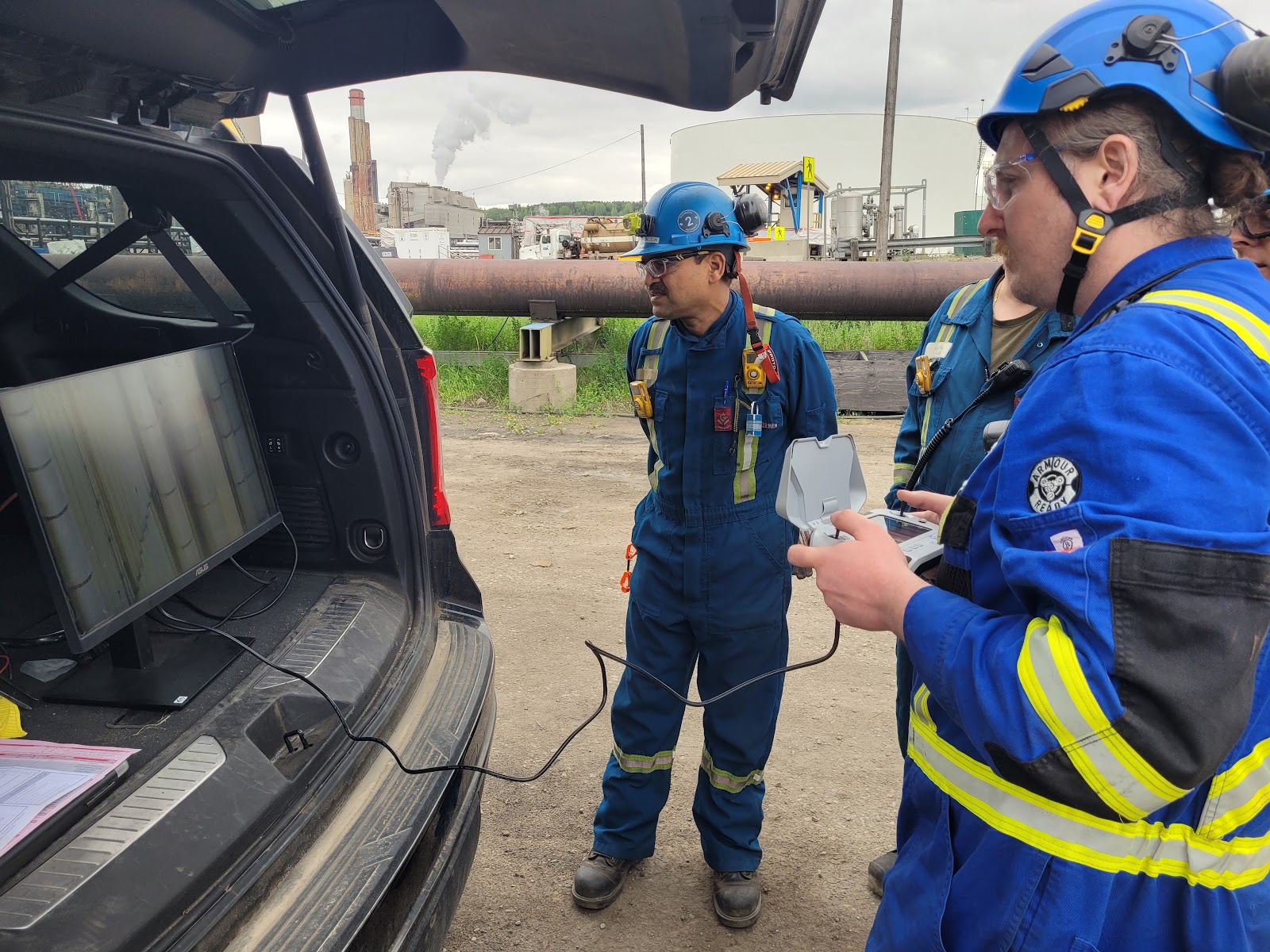 Field team reviewing drone data at an industrial truck operation